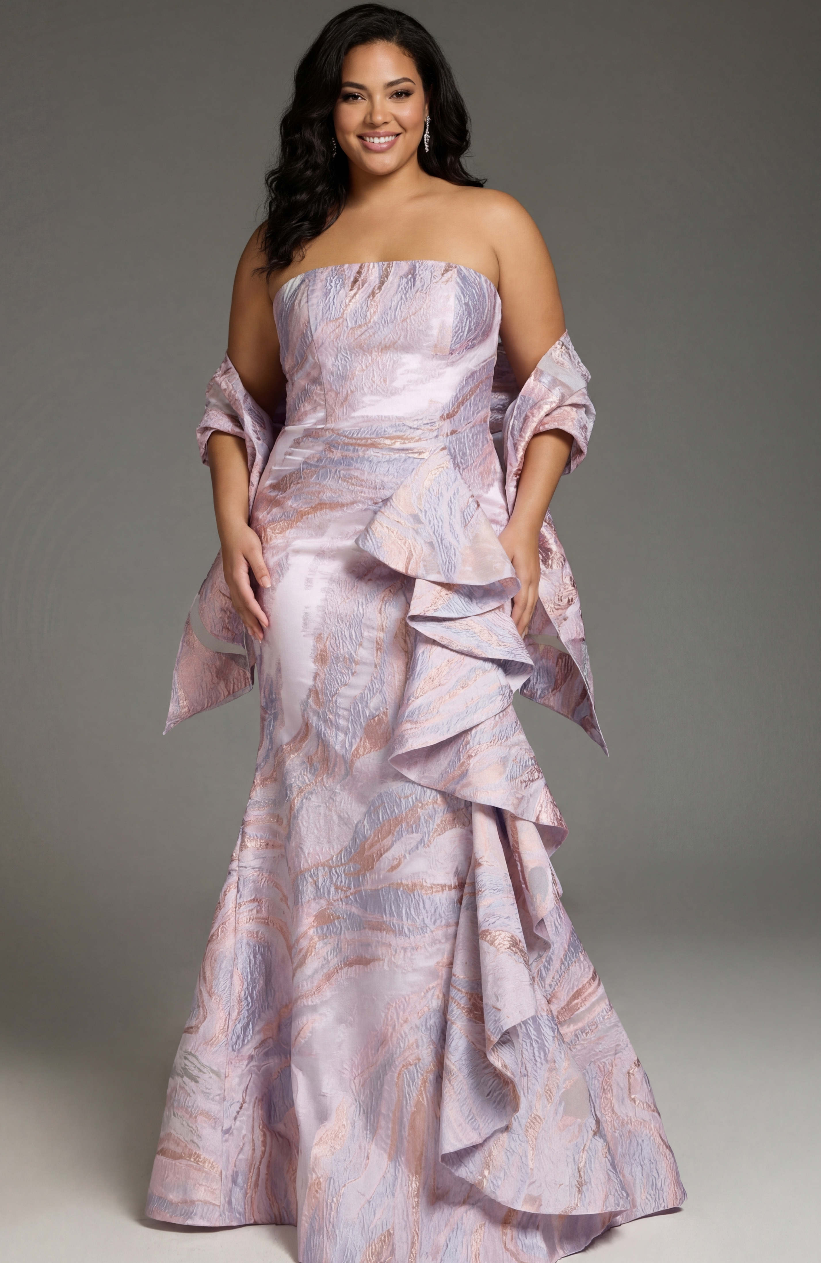 Elegant strapless gown with textured pastel fabric and cascading ruffle detail.