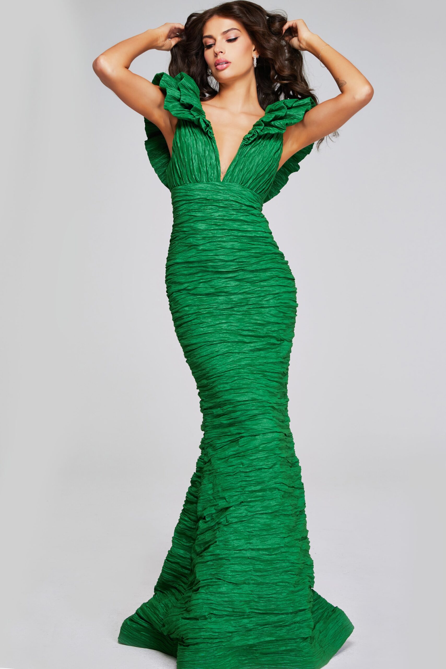 Model wearing Jovani 40044 green mermaid dress with ruched detailing and ruffled sleeves