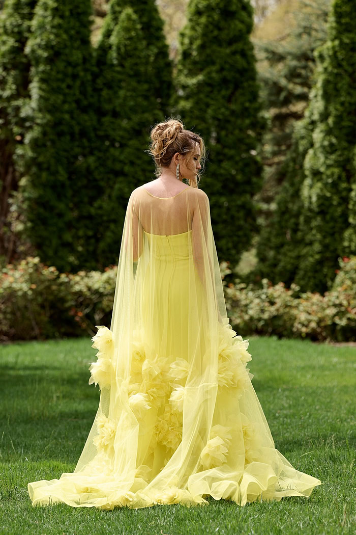 Model wearing Jovani 40092 yellow gown with floral appliqués, back view