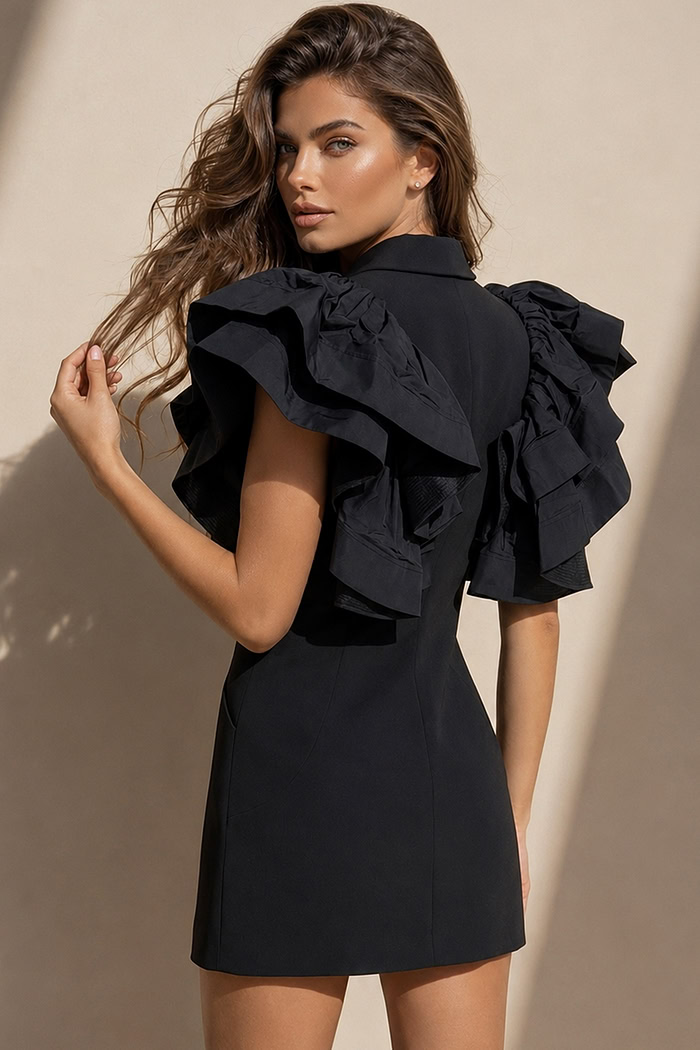 back view of black blazer mini dress with plunging V-neck, ruffle sleeves, and jeweled button