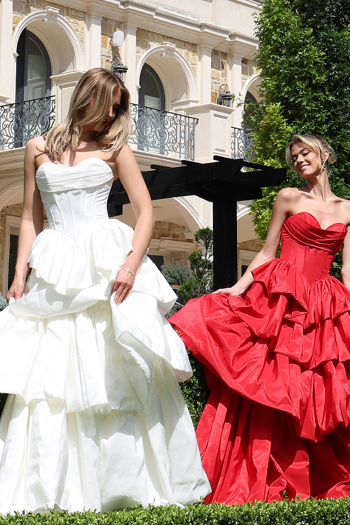 strapless layered ruffle ball gown - two girls front, hair covering face smiling fanning skirt