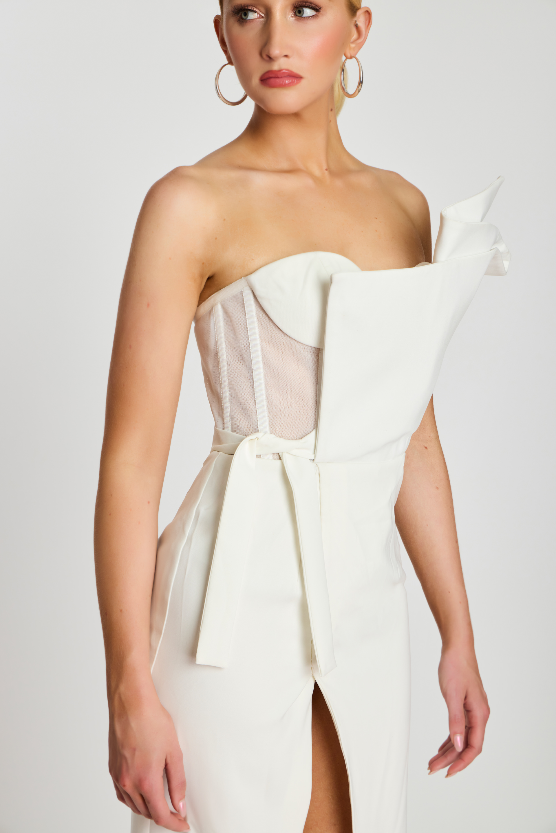 One-shoulder ivory midi dress with sculpted neckline, high slit, and fitted waist