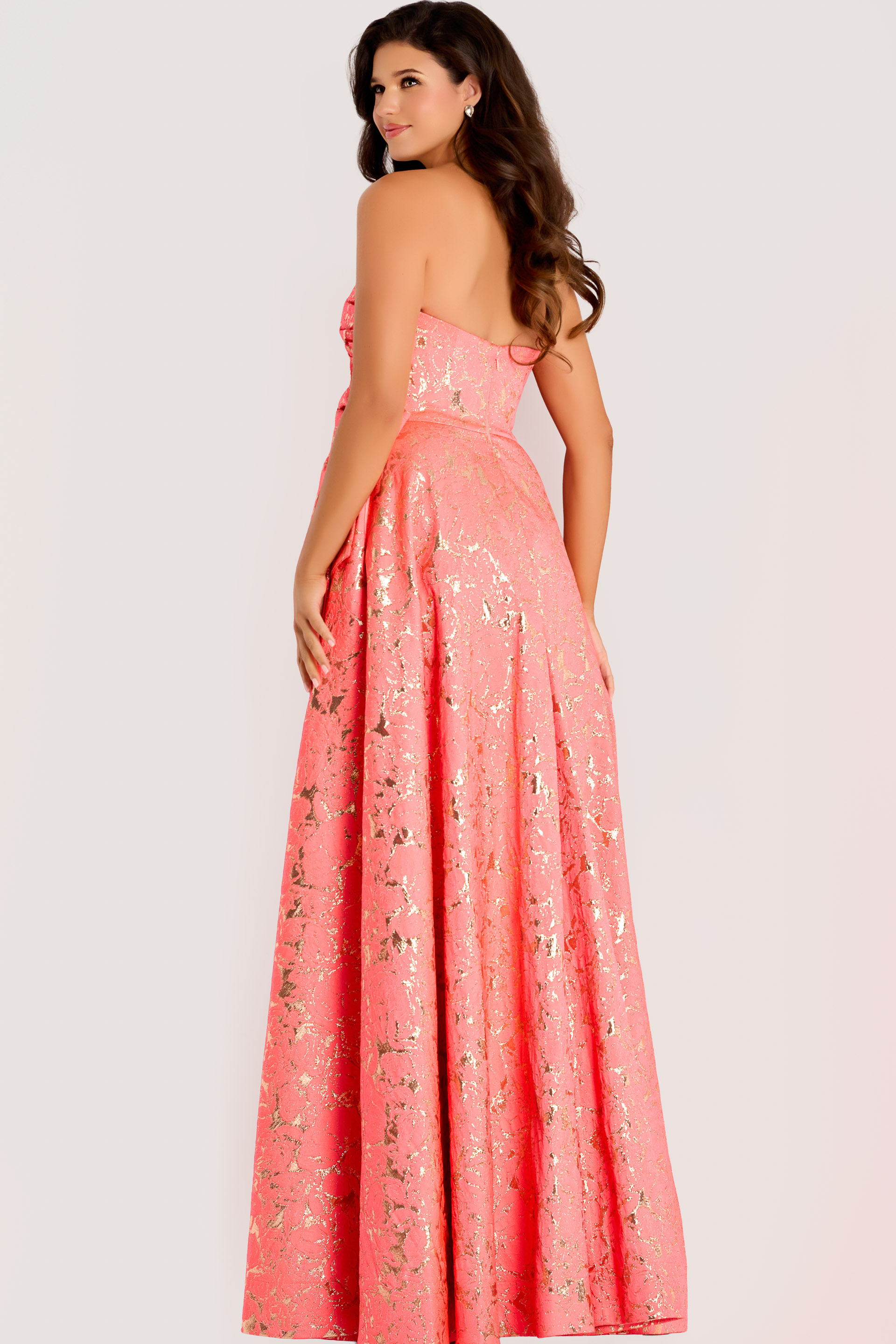 Strapless metallic jacquard gown with a fitted bodice and full A-line skirt accented by gold foil detailing.