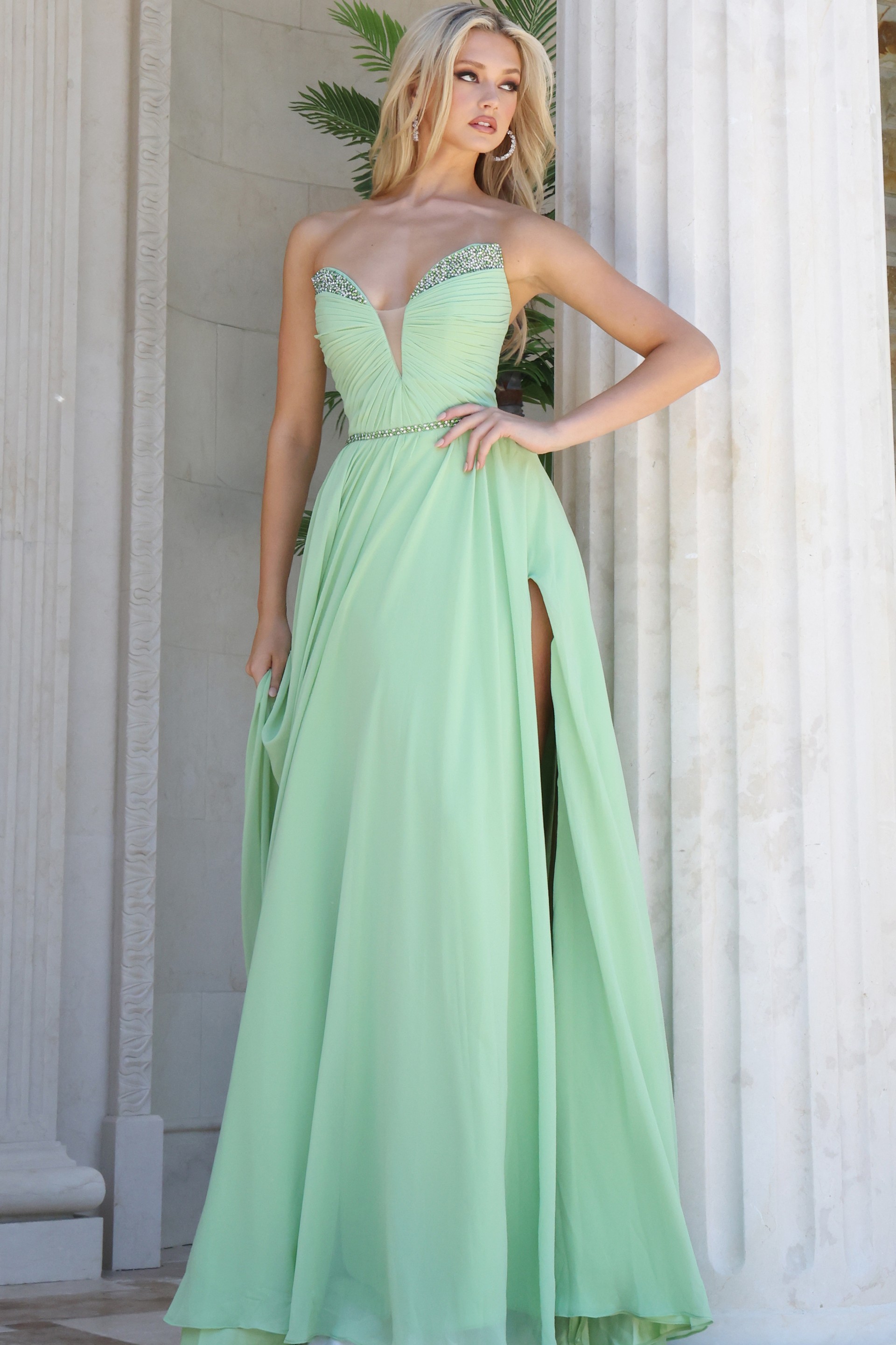 mint strapless coral chiffon a-line gown - front full body, hand on hip, looking left, prominent thigh slit
