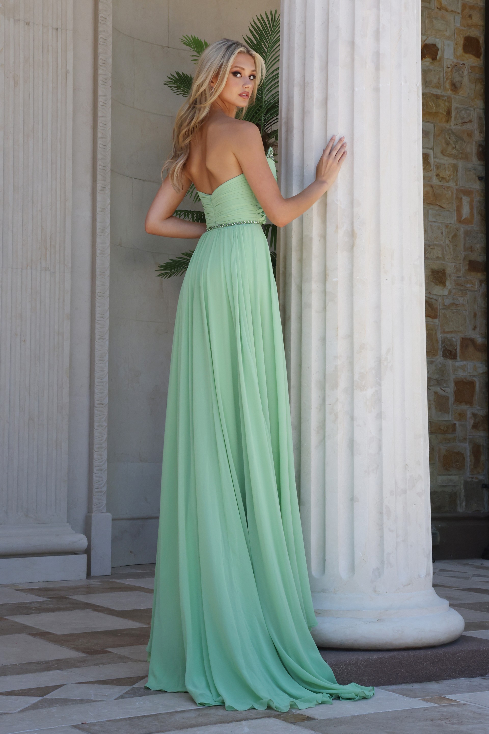 mint strapless coral chiffon a-line gown - three quarter view, leaning column looking over shoulder