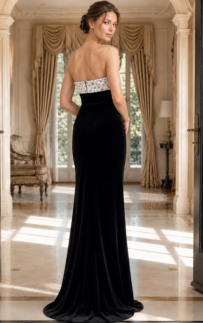 back view of black velvet strapless sheath gown with high slit