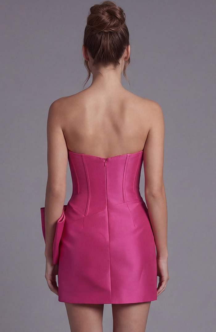 Back view of a hot pink strapless mini dress showing a fitted back with a hidden zipper closure and tailored seams.