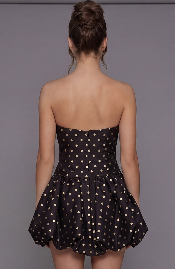 Rear view of a gold polka dot bubble dress showing the fitted bodice with a hidden zipper and voluminous skirt.