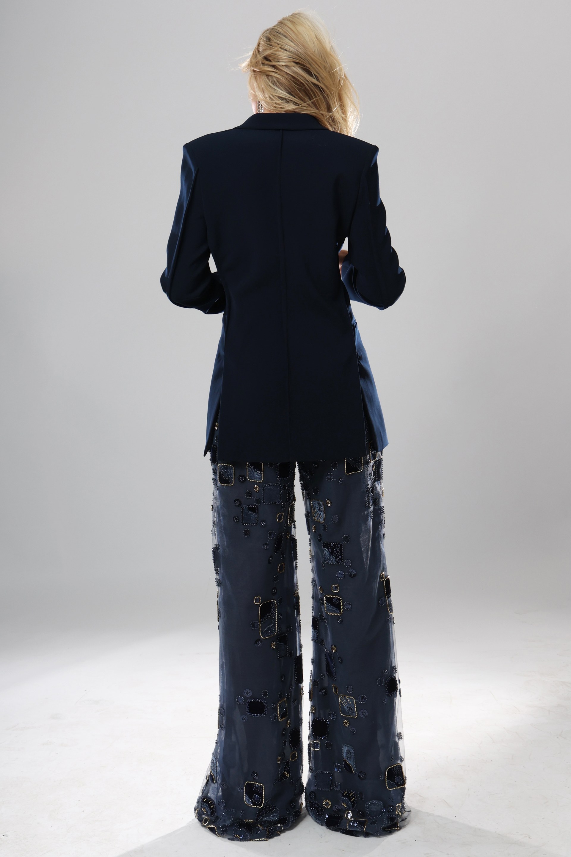 back view of navy beaded blazer jumpsuit with plunging neckline, gold buttons and sheer embellished wide leg pants, Jovani style 52096
