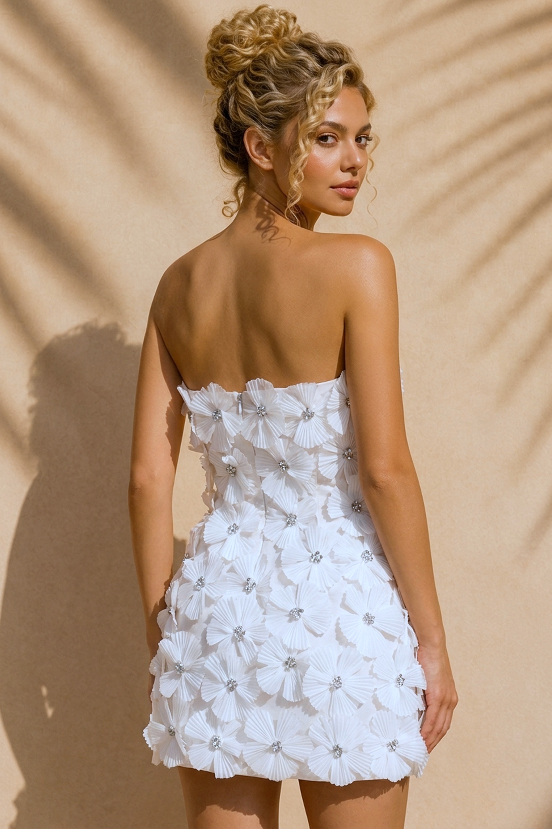 back view of white 3D floral strapless mini dress