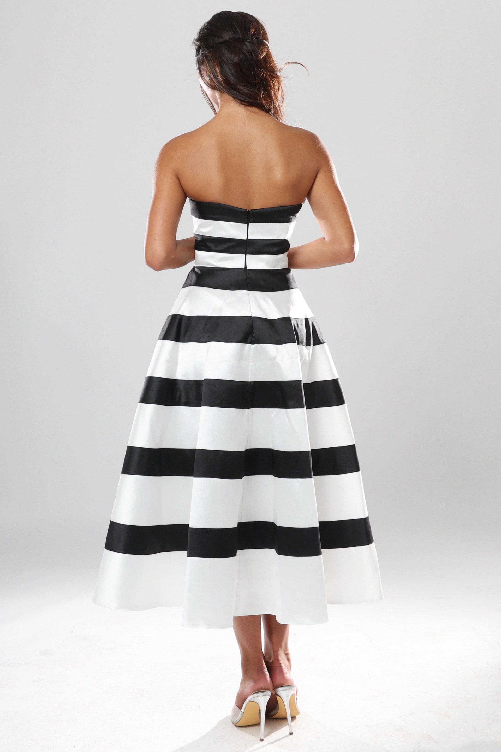 back view of black and white striped strapless A-line midi dress with straight neckline and pleated skirt, Jovani style 53462