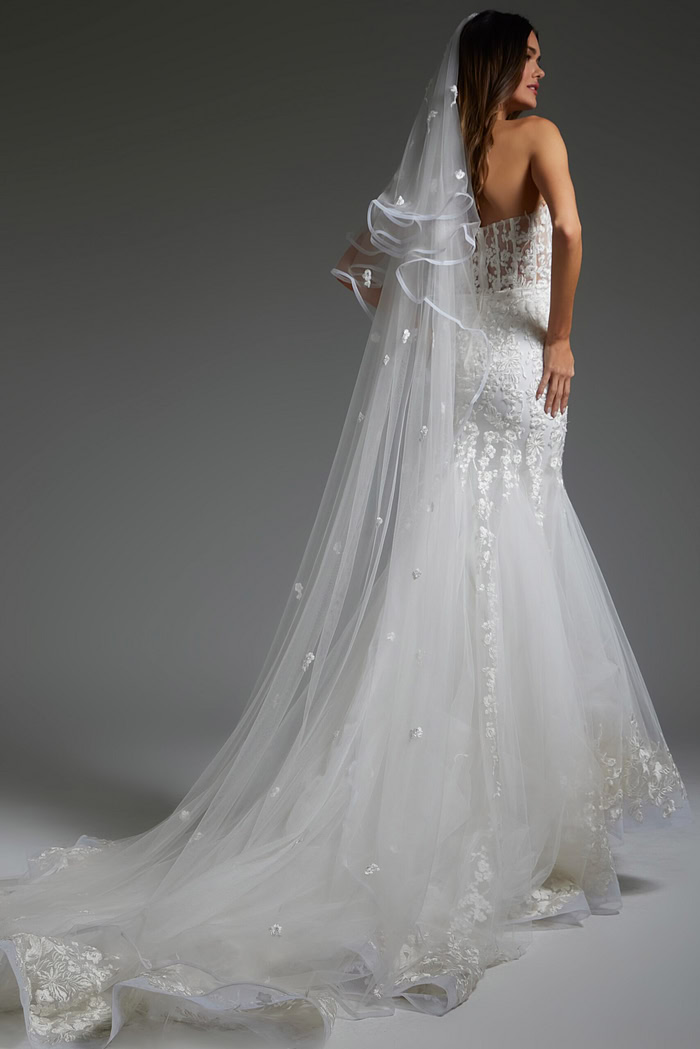 Model showing the Jovani JB07260 gown's lace detail and flowing train, back view.