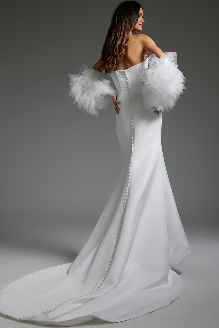 Back view of model in Jovani JB40601, white mermaid gown with button detail.