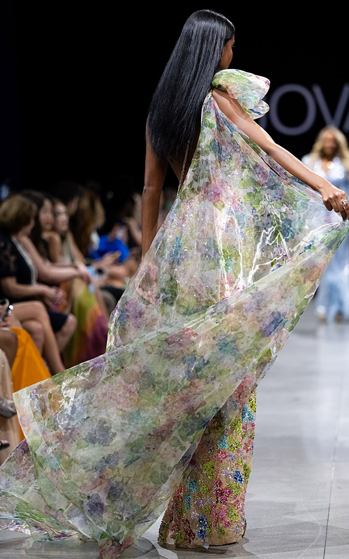 Model wearing Jovani S37492 multi-color floral gown with high slit and one-shoulder neckline.