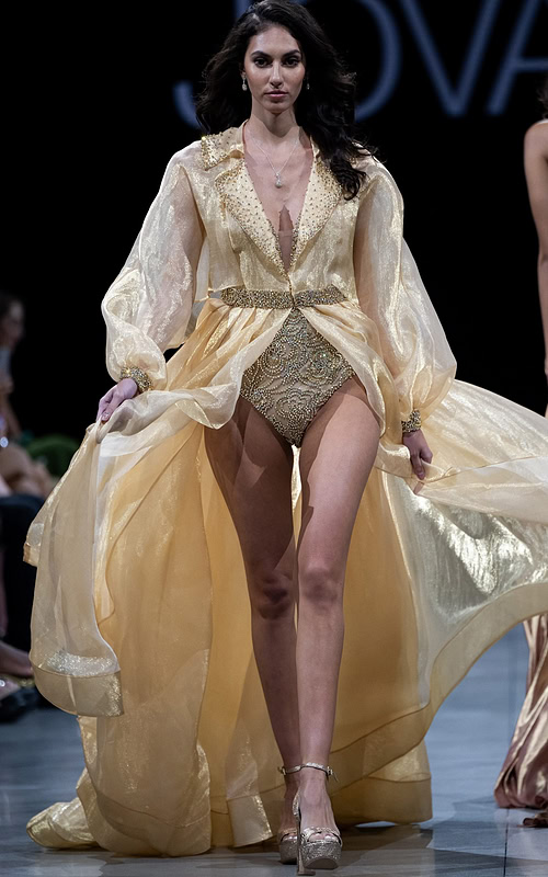 model wearing Jovani S38445 gold dress with V-neckline and voluminous sleeves